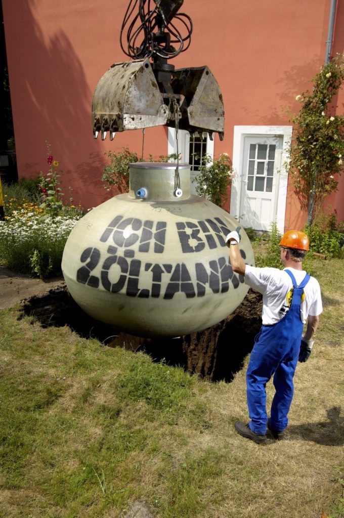 Nun kann der Erdtank eingesetzt werden und die Grube wird wieder verfüllt.