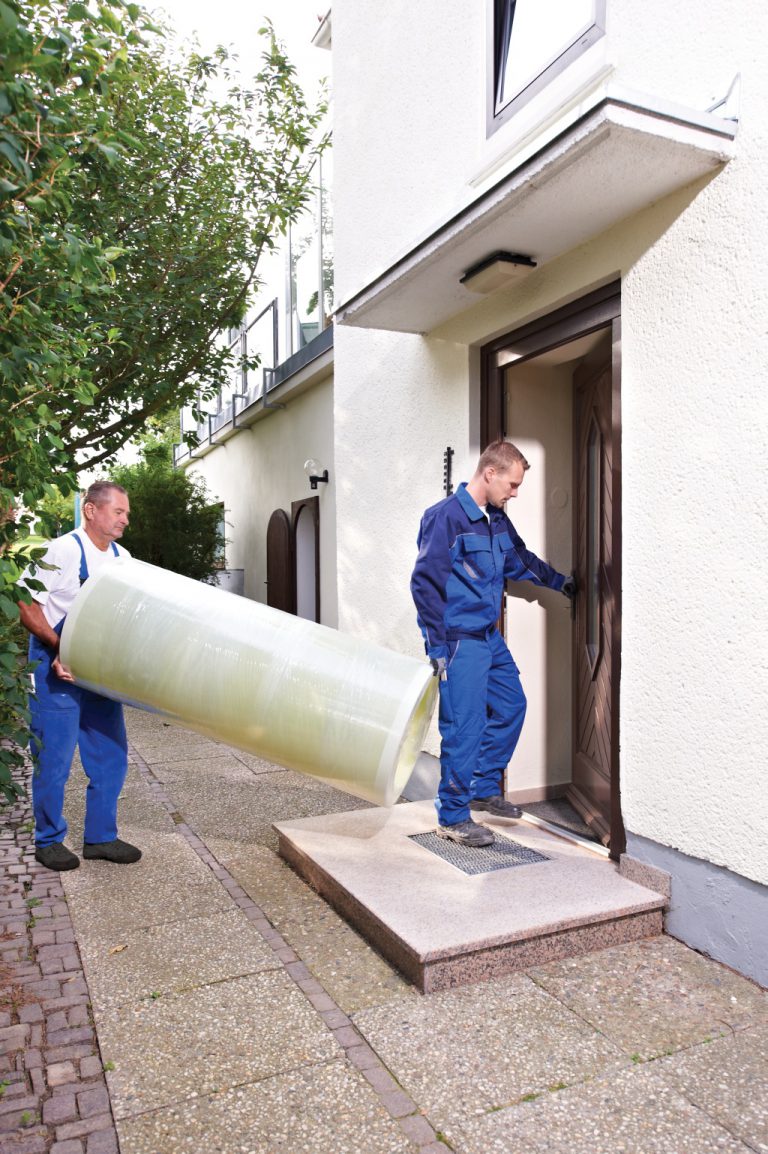 The individual parts of the Haase basement tank are carried into the house.